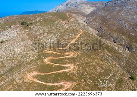 Drone photography from the winding country road to the top of Attavyros Mountain. Rhodes Island, Greece.  Royalty-Free Stock Photo #2223696373