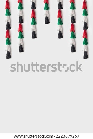 Decorative bunting for UAE National day celebration. An empty white space with hanging tassels with UAE national flag colors.  Royalty-Free Stock Photo #2223699267