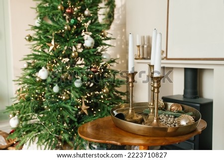 White candles in gold candlesticks on the coffee table in the Christmas decor of the living room