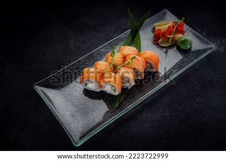 Sushi roll Philadelphia on a dark background, on a glass plate