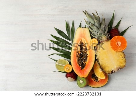 Exotic fruits on white wooden background, space for text. Royalty-Free Stock Photo #2223732131