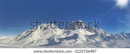 panoramic view on peak mountain covered with snow under sunny blue sky 