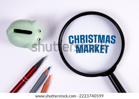 Christmas Market. Magnifying glass and piggy bank on white background.