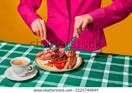 Woman eating English breakfast with fried eggs, bacon, sausage, mushrooms and tomato on green tablecloth with coffee. Vintage, retro style. Food pop art. Complementary colors. Copy space for ad, text