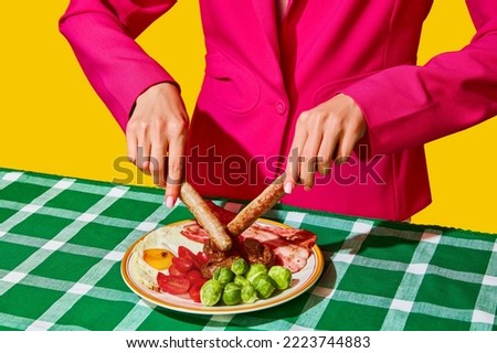 Funny image of woman eating English breakfast with sausages, fried eggs, Brussels sprouts and tomato. Vintage, retro style. Food pop art photography. Complementary colors. Copy space for ad, text