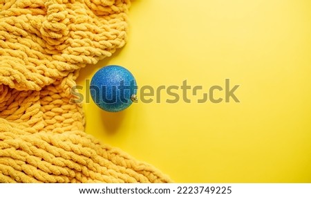Christmas decorations and a yellow blanket on a yellow background. cozy Christmas composition. copy space, top view, flat lay style