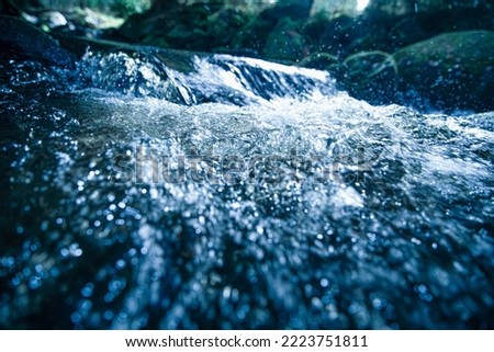 BLUBBLING WATER STREAM, FRESH BLUE BACKDROP, COLD WATER RIVER IN MOUNTAIN LANDSCAPE, NATURAL REFRESHING DESIGN Royalty-Free Stock Photo #2223751811