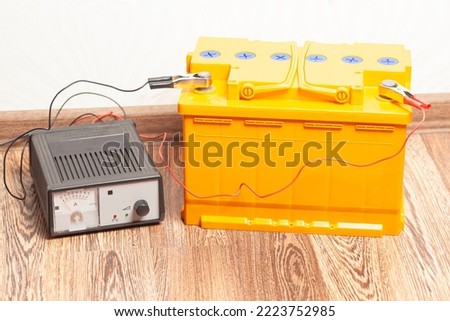 yellow car battery with car battery charger.