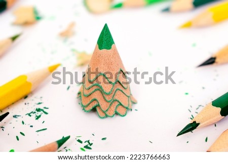 Colored pencils and creative Christmas tree made of shavings from a green pencil.Christmas and New Year flat lay on a white background.