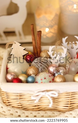Basket with various Christmas ornaments and knitted blanket. Selective focus.