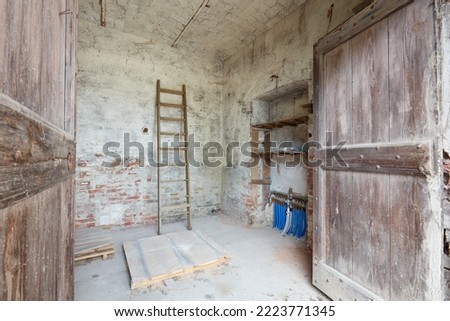 Old depository room with wooden portal in old country house Royalty-Free Stock Photo #2223771345