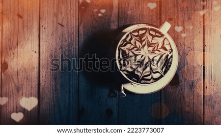 A cup of cappuccino with a beautiful latte art pattern with heart patterns and bokeh lights for Valentine's Day