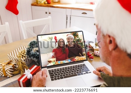 Senior caucasian man having christmas video call with caucasian couple. Communication technology and christmas, digital composite image.