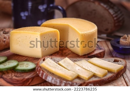 hard cheese with bread - still life with served slice of bread and sliced hard cheese loaf on a tray and chopping board Royalty-Free Stock Photo #2223786235