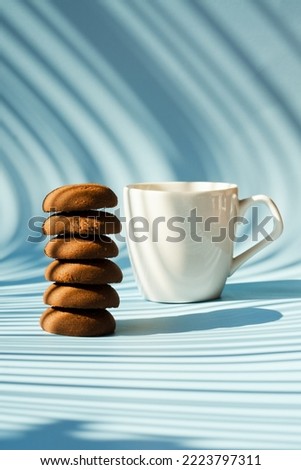 Cup of hot coffee and sweet cookies on blue background. Top view, copy space, mockup. Flat lay. Food and drink.