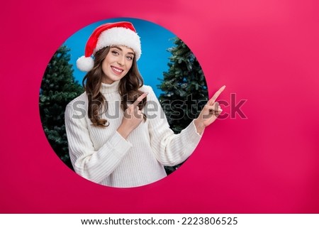 Photo of cute funny lady wear santa claus helper xmas hat breakthrough background hole empty space isolated red color background