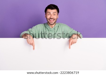 Photo portrait of handsome young man excited point white wall empty space wear trendy gray outfit isolated on violet color background