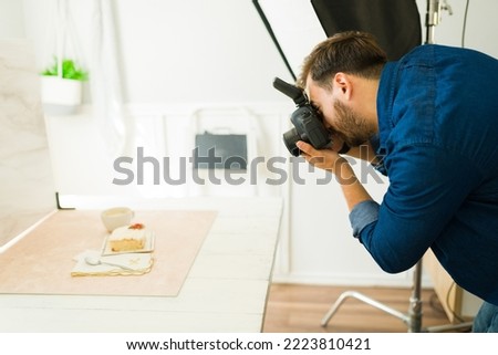 Side view of a male photographer at his studio doing a professional food photo shoot 