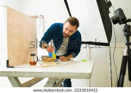 Professional photographer doing food styling during a photo shooting at his professional studio
