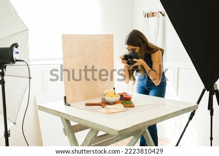 Latin food photographer doing a photo shoot at her professional studio with good lighting 