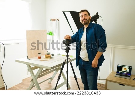 Happy caucasian photographer smiling while working at the photography studio doing a  photo shoot