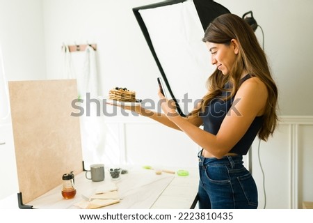 Smiling woman photographer doing food styling and preparing to take professional photos at her studio