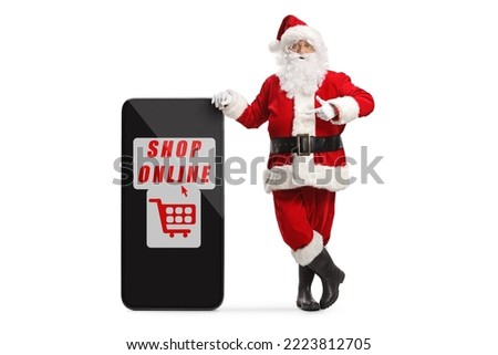 Full length portrait of santa claus pointing at a smartphone with text shop online isolated on white background