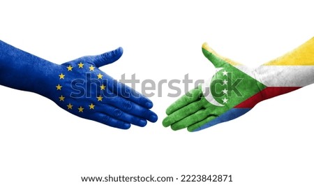 Handshake between Comoros and European Union flags painted on hands, isolated transparent image.