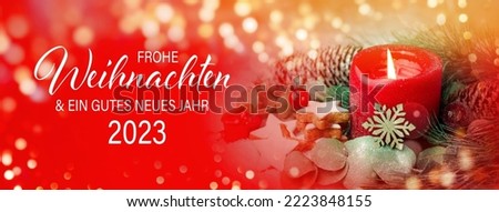 Christmas greeting card with text in German -  Frohe Weihnachten means Merry Christmas and Happy New Year 2023 - Red burning advent candle with cookies and fir branches