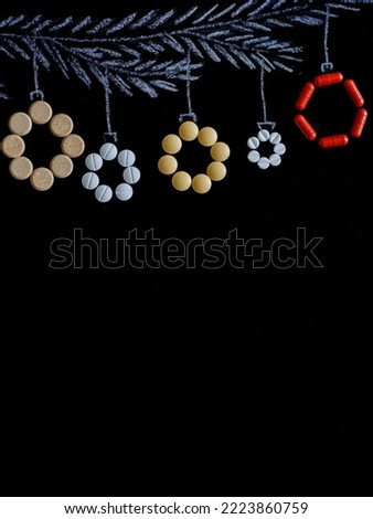 Drawing fir tree branch and pills or tablets like new year balls hanging on black chalk board background. Merry christmas and happy new year border, copy space. Pharmacy holiday concept. vertical.