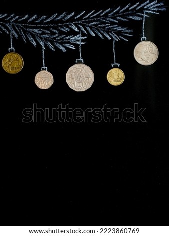 Drawing fir tree branch and australian dollars coins like new year balls hanging on black chalk board background. Merry christmas and happy new year, wealth wishes for business. Copy space. Vertical.