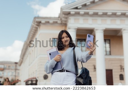 Portrait of thai student girl taking a self portrait with smart phone. Modern millennial youth lifestyle and travel concept. People and technology concept.