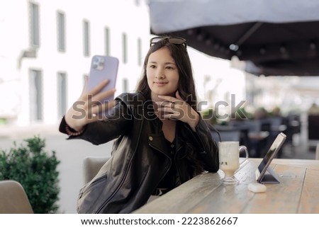 Portrait of thai student girl taking a self portrait with smart phone. Modern millennial youth lifestyle and travel concept. People and technology concept.