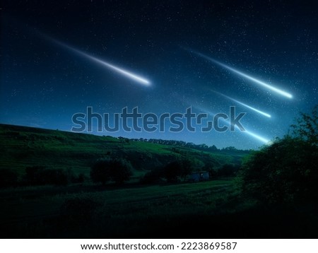 Night landscape with meteors in the starry sky. Beautiful shooting stars over green hills and trees. Falling meteorites.