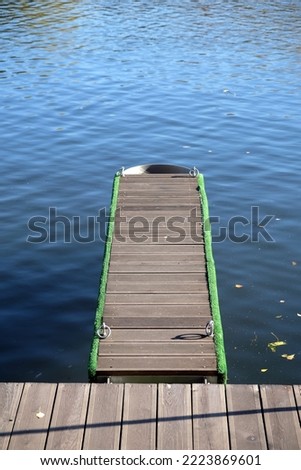 Pier and mooring for small boats, going into the water, in a calm river close-up photo