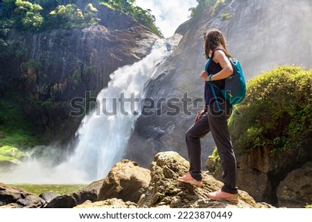 Woman tourist and Dunhinda waterfall in a sunny day in Sri Lanka Royalty-Free Stock Photo #2223870449