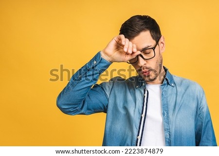 People, crisis, emotions and stress concept - unhappy tired man suffering from head ache at home. Isolated over yellow background. Royalty-Free Stock Photo #2223874879