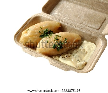 Lithuanian national dish - potato dumplings (zeppelins) with meat and mushroom sauce, sour cream, parsley. Takeaway box. Sustainable packaging