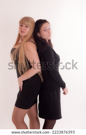studio portrait of two girls in black dresses