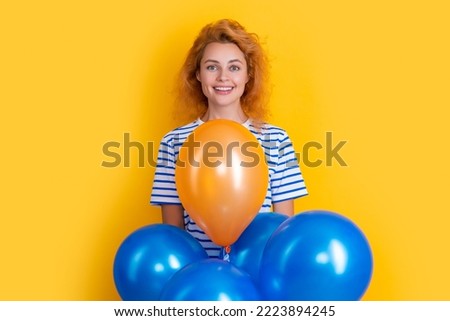glad woman hold party balloons in studio. woman with balloon for party isolated on yellow