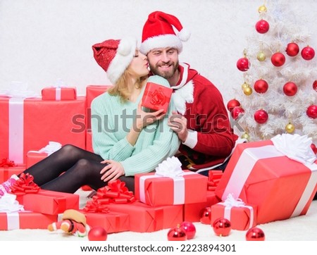 Couple sit near pile of gift boxes and christmas tree background. Couple in love enjoy christmas holiday celebration. Opening christmas present. Pleasant surprise. Husband prepared christmas surprise