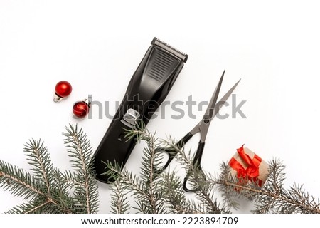 Christmas composition. Hairdressing scissors, clipper and spruce branch on a white background. Template for a postcard or information about a hair salon. Flat lay, copy space.
