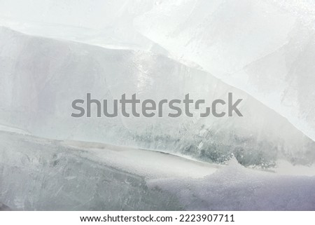 Transparent blue ice hummocks on lake Baikal shore. Siberia winter landscape view. Snow-covered ice of the lake Royalty-Free Stock Photo #2223907711