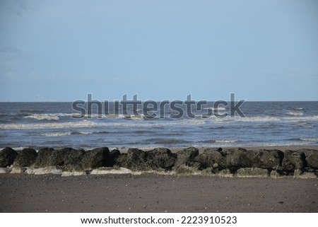Waves crashing onto a beach with a cloudy sky background and no people. Taken in Cleveleys Lancashire England.