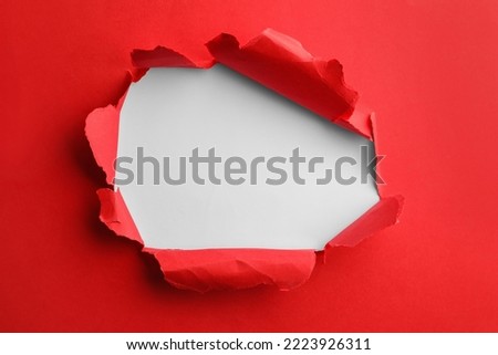 Hole in red paper on white background Royalty-Free Stock Photo #2223926311