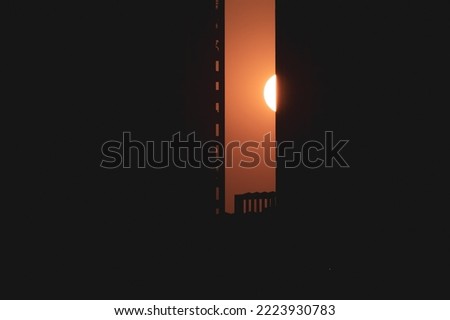 Sun setting between two high rise skyscrapers in the city of Mumbai.
