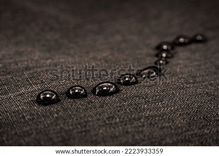 Drops of water on textiles. Waterproof fabric with drops on the surface Royalty-Free Stock Photo #2223933359