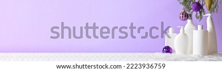 Christmas cleaning. A large horizontal banner with plastic white bottles with detergent for disinfection with fir branches and Christmas tree toys on a light purple background. Copy space.