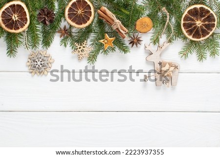 Christmas composition with branches of a Christmas tree and eco-natural decorations, orange, cinnamon on a white wooden background. Happy New Year. Space for copying. Flat position, top view.