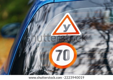 The novice driver attached the Y and 70 km sign to the rear window of the car. Speed limit sticker for beginners. Royalty-Free Stock Photo #2223940019